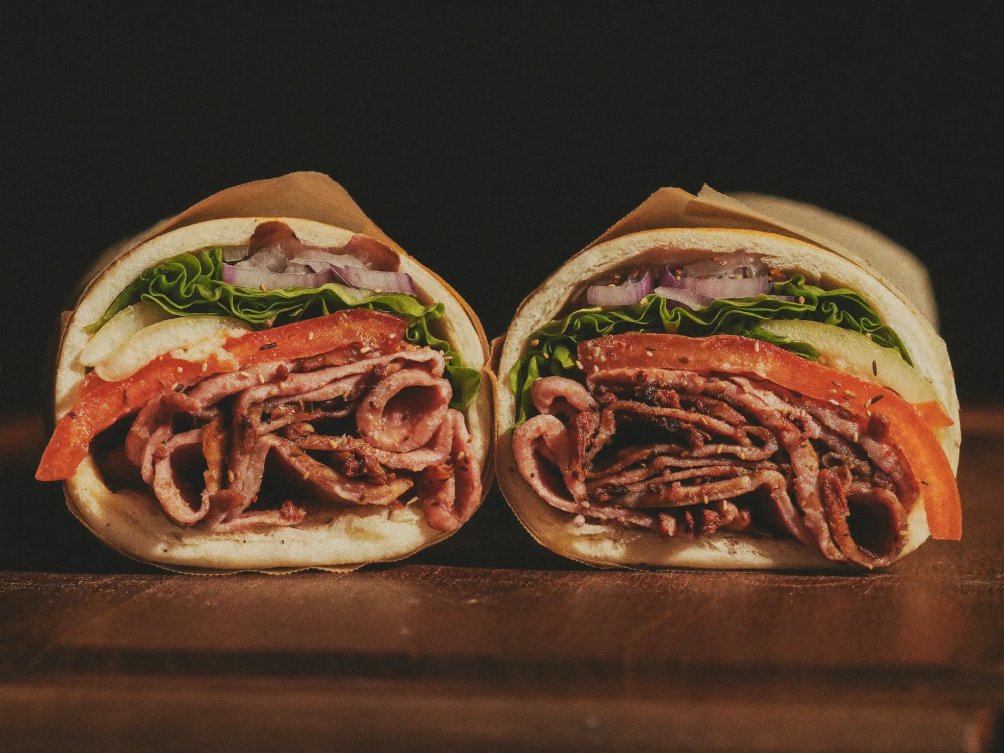 Doner wrap cut in half showing layers of meat and vegetables